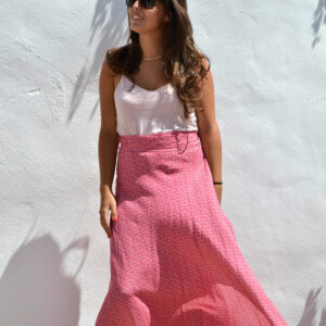 mujer con una falda larga estampada color pink delante de un muro