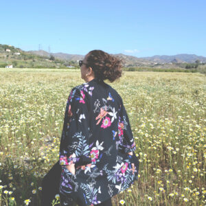 woman looking at a field of daisies