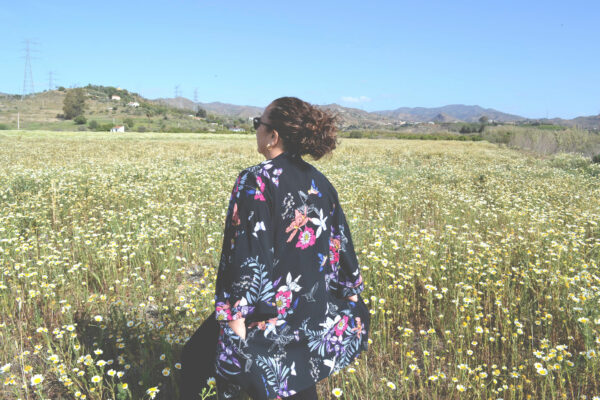 woman looking at a field of daisies