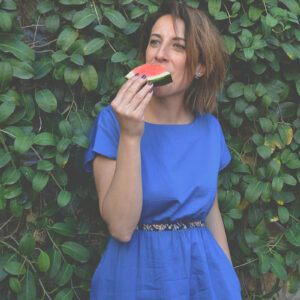 woman eating watermelon wearing organic cotton dress