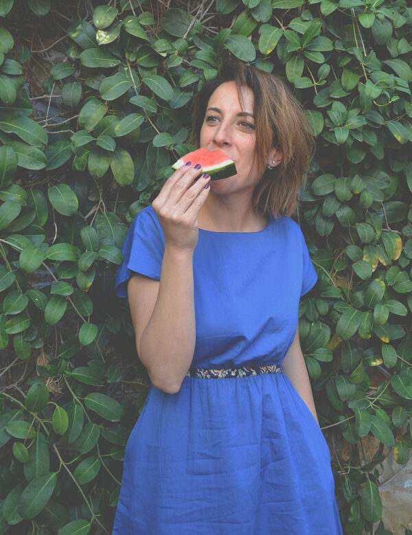 woman eating watermelon wearing organic cotton dress